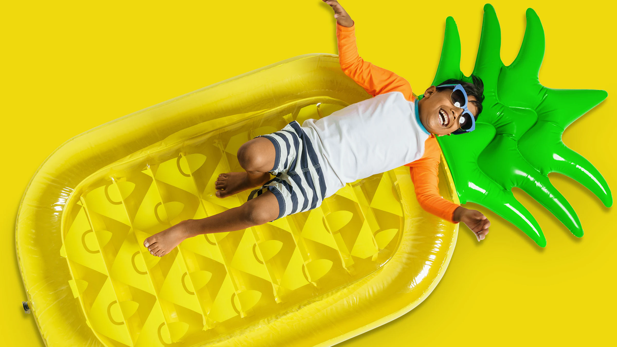 Young child laying on pineapple floaty