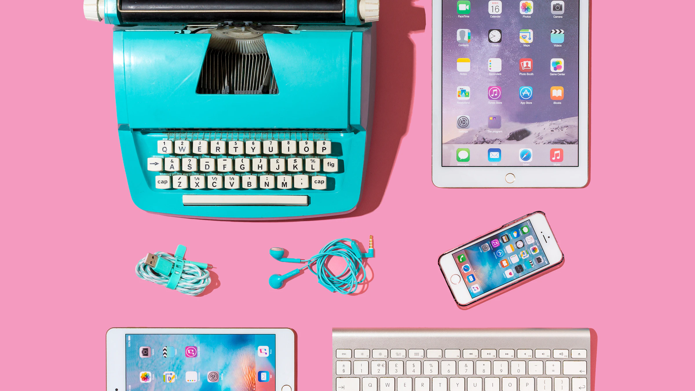 Various electronic handheld devices and typewriter against bright pink background technology for aging adults